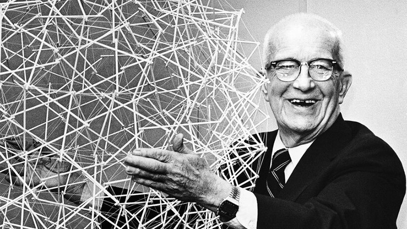 Buckminster Fuller smiling and holding a wirefram version of his famous Buckyball