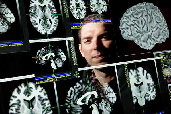 Composite of Dr. Barbey with a number of brain scans.